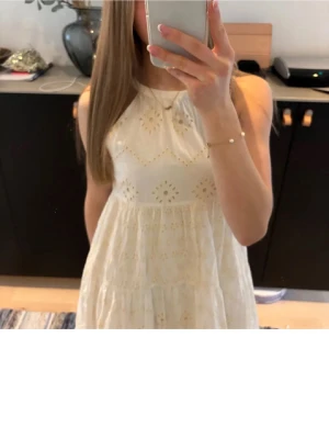 Vit somrig klänning med broderi - Söt vit klänning med broderade detaljer och volange från Zara. Klänningen är bara använd nån enstaka gång och är i mycket bra skick