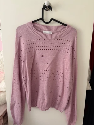 Ljuslila/rosa stickad tröja från VILA - Söt ljuslila stickad tröja från VILA med hålmönster och rund halsringning. Tröjan är köpt från VERO MODA men är från märket VILA, den är aldrig använd  utan bara testad, och nypriset är 449kr💞💞