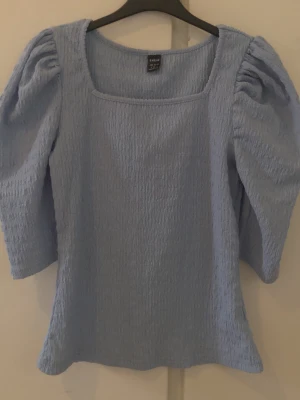 Ljusblå puffärmad topp från Shein - Supersöt ljusblå topp från Shein med puffiga trekvartsärmar och fyrkantig ringning. Materialet är lätt strukturerat och stretchigt, vilket ger en bekväm passform. Perfekt att styla med jeans eller kjol. Skriv om du vill se den på, pris kan diskuteras ❤️