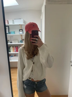 Blå denimshorts med fransar - Säljer ett par klassiska blå jeansshorts med råa franskantade benslut och femficksmodell. Shortsen har låg midja och en avslappnad passform, perfekta för varma dagar. Snygga att matcha med en enkel topp eller hoodie. Storlek 152 men passar mig som brukar ha 152