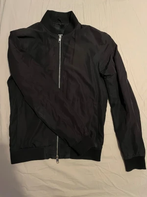 J.Lindeberg jacka - Säljer denna riktigt fina vindjackan från J.Lindeberg. Den är i väldigt bra skick, inga skador eller slitage. Den har dubbelzip och en innerficka och 2 zip stängda framfickor. Nypris ungefär 3000kr~