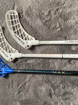 Unihoc innebandyklubbor Superskin - Tre innebandyklubbor från Unihoc, modellerna Superskin Pro och Superskin Max.  De är 92cm långa med 29flex. Skriv ifall du har intresse 