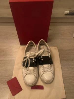 Valentino Open - Snygga vita sneakers från Valentino med bred svart läderdetalj. Den är använd men har inga större defekter. Storlek 38 men kan även passa som 39💕💕