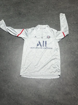 PSG långärmad träningströja vit/grå - Snygg vit långärmad träningströja från PSG och Jordan. Jag säljer den då jag inte har på mig den alls. Perfekt för dig som kör fotboll ⚽️ 