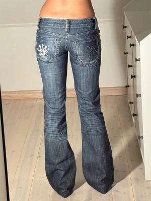 Lågmidjade bootcut jeans  - Midjemått: 33cm. Innerbenslängd: 80cm. (Framknapp utbytt.) Kolla in min profil, följ för fler plagg🙌