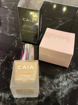 CAIA 2W  It's Iconic Liquid Silk Foundation + Primer - Foundation och primer från CAIA i nyansen 2W (warm). Kommer i en frostad glasflaska med silvrig pump och tillhörande förpackning. Innehåller hyaluronsyra och vitamin C samt har SPF 20. Ger en naturlig finish  och känns lätt på huden.