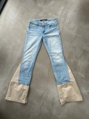 Ljusblåa jeans med beige utsvängda ben - Säljer dessa lågmidjade ljusblå jeans från Marc O'Polo som jag sytt om till bootcut. Har väldigt skönt och stretchigt material och sitter fint på. Skriv för frågor💕