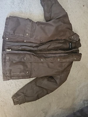 Brun jacka från Massimo Dutti - Snygg brun jacka från Massimo Dutti med flera fickor och knappar framtill. Jackan har en rak passform och är passande till våren då det är en dubbeljacka. Enda anledningen till att jag säljer den är för den var för stor. Storlek L men upplevs som en M