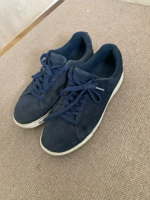 Mörkblå sneakers från pier one - Snygga mörkblå sneakers från pier one med klassisk låg profil och vita sulor. Skorna har ovandel i mockaliknande material och matchande mörkblå skosnören. Perfekta för en clean och stilren look.