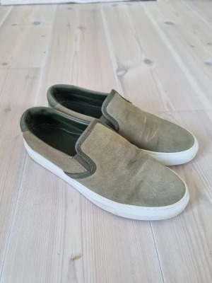 Diemme loafers - Snygga slip-on sneakers från Diemme i olivgrön mocka med gröna skinnpaneler och vit platt sula. Skorna har rund tå och en stilren, minimalistisk design som passar perfekt till jeans eller shorts. Insidan är fodrad med grönt skinn för extra komfort