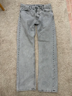 Ljusgråa Hope Rush Jeans Bootcut - Säljer ett par riktigt snygga jeans från Hope i modellen Rush. Storlek 30. Byxorna är varsamt använda men har lite slitningar (se bilderna) i hälen och lite slitet i skrevet.