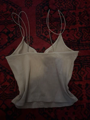 Beige linnetopp - Säljer en beige ribbad linnetopp med tunna axelband och enkel, stilren design. Materialet känns skönt. Funkar perfekt för S och xs