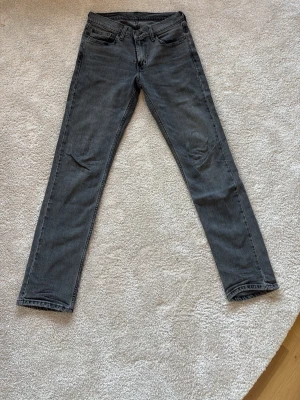 Grå Levi's 511 slim jeans - Säljer ett par grå Levi's 511 slim Jeans i storlek W29 L32. Jeansen har en snygg tvättad look och är tillverkade i bomull med lite stretch för extra komfort. Perfekta för dig som gillar en smalare passform. Använda max 5 gånger