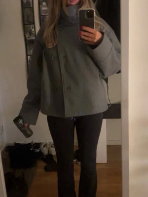 Grå kort kappa  med hög krage - Säljer min otroliga kappa från Gina Tricot, storlek M, sparsamt använd och väldigt fint skick