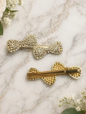 Glittriga hårspännen med rosett - 1 st hårspännen i form av rosetter, täckta med gnistrande strass och guldfärgad metall. Perfekta för att ge frisyren extra bling och en söt touch. Lätta att fästa i håret och passar till många olika stilar.