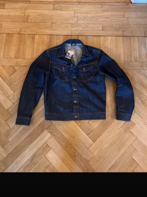 Nudie Jeansjacka ”Sunburn” - Saljer en Nudie Jeans jacka med "sunburn" logga (limited edition) i storlek M, köptes för 2000 kr och säljes då jag hemma kom på att den inte riktigt passade mig i storleken