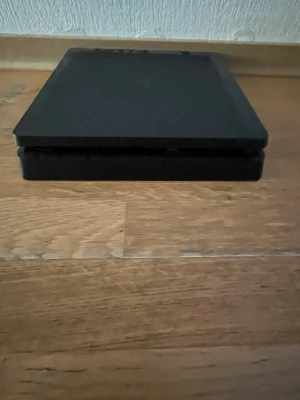 Playstation 4 Slim spelkonsol svart - Säljer en svart PlayStation 4 Slim från Sony. Konsolen har en stilren, rektangulär design med mattsvart finish och är tillverkad i plast. Perfekt för gaming och streaming av filmer och serier.