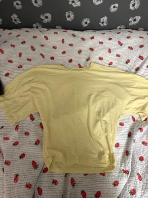 Ljusgul t-shirt med loose fit - Ljusgul t-shirt med loose passform och rund halsringning. T-shirten är enkel och stilren utan mönster eller tryck, perfekt för dig som gillar en avslappnad look. Materialet känns mjukt och bekvämt, troligtvis bomull.