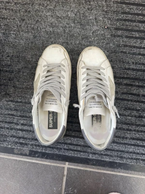 Golden goose - Säljer dessa golden goose med lite slitningar på inre och yttre sula men inget som syns mycket fortfarande i bra skick. Box och äkhetsbevis kommer med, storlek 40 men skulle säga att dom är lite stora i storleken<3