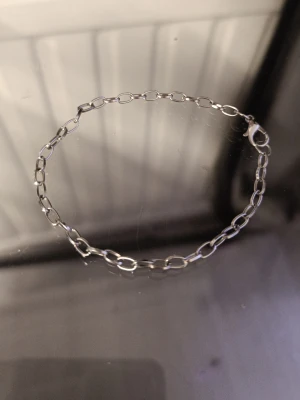 Silverfärgat kedjearmband - Stilrent armband i silverfärg med ovala länkar och karbinlås. Perfekt för dig som gillar minimalistiska accessoarer och vill ha något som funkar till många olika looks. Materialet är metall och designen är enkel men ändå trendig.
