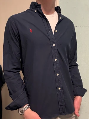 Marinblå Ralph Lauren skjorta – M Slim Fit - Säljer denna stilrena och snygga marinblåa Ralph Lauren skjorta. Skjortan är i mycket bra skick. Modellen är M slim fit. Har du några frågor? Tveka inte att höra av dig. Allt gott från Deluxe garderoben ⭐️ 