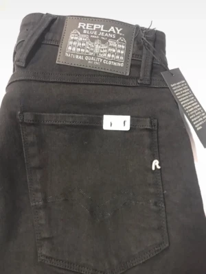 Svarta  Replay jeans  - Snygga svarta slim  jeans från Replay med klassisk femficksdesign och detaljer som logotyp på bakfickan och patch i midjan. Jeansen har smal passform och är tillverkade i stretchigt material för extra komfort.