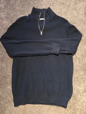 Mörkblå stickad tröja från Zara - Tjena! säljer nu min snygga mörkblå stickade tröja från Zara med halv dragkedja och hög krage. Tröjan har ribbstickad struktur och långa ärmar, perfekt för en clean look. Bara att höra av sig vid någon fundering!
