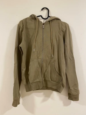  zip-hoodie med fickor - En enkel grön/brun hoodie med dragkedja framtill och fickor. 
