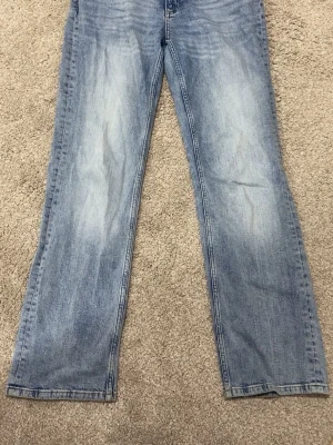 Ljusblå raka jeans från Nelly använt ett par gånger strorlek 36 - Säljer ett par ljusblå jeans med rak passform och klassisk femficksdesign. Jeansen har en snygg tvättad look och är tillverkade i denim. Perfekta för en avslappnad stil. Från Nelly 