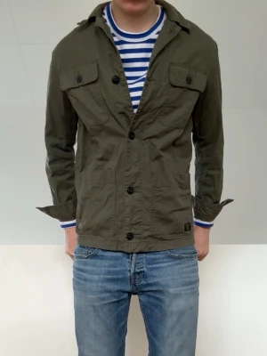 Olivgrön Overshirt - Säljer en sjukt fet overshirt i färgen olivgrön! Skjortan är i bra skick utan defekter då den varit väl omhändertagen. Hör gärna av er vid frågor elr funderingar!!