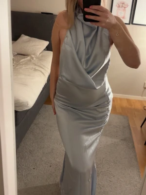Balklänning  - Superfin ljusblå klänning i satin med halterneck och draperad framsida. Perfekt passform, normal i storlek. Säljer då jag har en annan och denna inte kommer till användning. Köpt från aboutyou!🩵