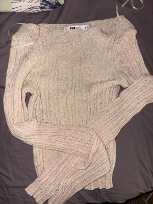 Beige ribbstickad tröja  - Säljer en beige ribbstickad tröja från Faster. Tröjan har lång ärm, rund halsringning och är gjord i ett mjukt, stretchigt material. Perfekt för lager på lager och enkel att matcha med olika outfits.