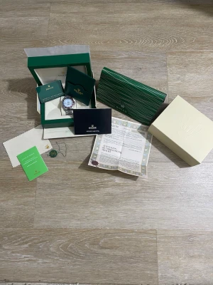 Rolle silverfärgad klocka med länk - Exklusiv Rolle herrklocka i silver med klassisk länkarmband och rund urtavla. Klockan levereras med originalbox, certifikat, garantikort och tillbehör. Perfekt för dig som vill ha en tidlös accessoar från ett av världens mest ikoniska märken.