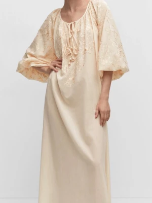 Ljus lång Interno-klänning från Mango -  sophi långklänning från MNG i ljusbeige plugin med bro lucky detaljer och baseline snörning framtill. Klänningen har shift nariga ballongärmar och är tillverkad i ett tunt, lätt material som känns luftigt och somrigt flexible. Strandklänning nypris 1499