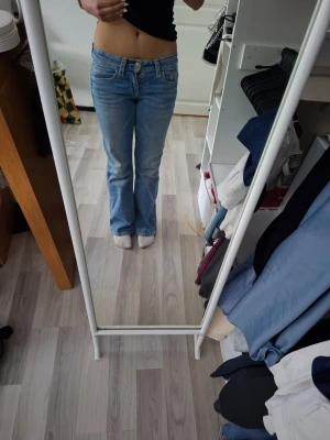 Ljusblå bootcut jeans - Säljer ett par ljusblå bootcut jeans från Gina Tricot. Jeansen har en klassisk femficksdesign och snygga paljett detaljer på bakfickorna. Använda endast en gång. Ny pris 400kr.