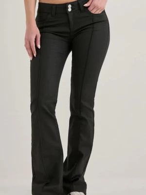 Coated jeans - Snygga svarta bootcut jeans med hög midja och dubbla knappar framtill. Jeansen har markerade sömmar längs benen och klassiska fem fickor. Tillverkade i ett stretchigt material som sitter bekvämt och formar sig efter kroppen.