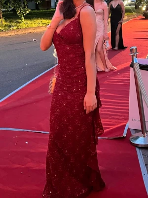 Vinröd glittrig långklänning - Väldigt fin klänning som passar perfekt till balen, använd endast 1 gång. Storlek S sitter väldigt fint med fin detalj på sidan som ni kan se i bilden. Klänningen är även väldigt uringad. För längd referens så är jag 165cm och har i bilden klackar på ca 3cm. Skriv gärna PM om ni vill se fler bilder ❤️