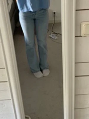 Ljusblå bootcut jeans - Säljer ett par ljusblå bootcut jeans med klassisk femficksdesign och normal midja. Jeansen har en avslappnad passform över låren och lätt utsvängda ben. Perfekta för en casual och trendig look. Materialet är mjukt denim i bomull.