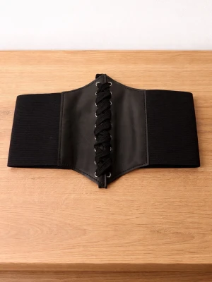 Svart midjekorsett med snörning - Säljer ett svart midjebälte i korsettstil med bred resår och snörning framtill. Bältet har detaljer i konstläder och elastiskt material som ger en snygg siluett. Perfekt för att lyfta en outfit med edgy vibe.