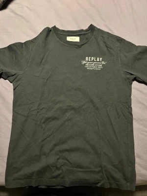 T-shirt från Replay - Skön grå/svart t-shirt från Replay tryck fram och bak. Klassisk passform och rund halsringning. Har bara används någon enstaka gång.