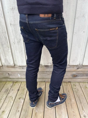 *Dry True Selvage* Nudie Lean Dean - Ett par mycket trevliga selvedge jeans från Nudie som kommer utveckla en mycket fin fade med tiden! Små fläckar vid knät som förmodligen går bort med lite hett vatten lokalt. Modellen kallas Lean Dean och sitter slim. Storlek 31/34 men utgå alltid från måtten! Mått: Midja - 41, Ytterbenslängd 107, Benslut - 16