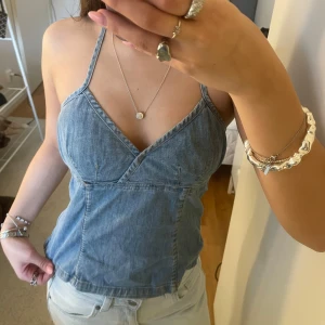 Blå jeanstopp  - En jättesöt halternecktopp i jeans från H&M. Det finns en dragkedja i sidan och band som man knyter i nacken. Figurnära passform som passar både xs/s. I fint skick🙏🏼💖