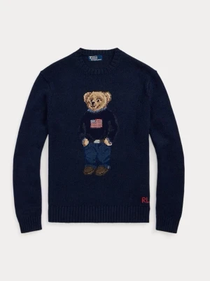 Mörkblå stickad tröja med björn - Mörkblå stickad tröja från Ralph Lauren med ikonisk björn på bröstet, klädd i jeans och tröja med amerikansk flagga. Rund halsringning och ribbade muddar. Perfekt för dig som gillar klassisk preppy stil.