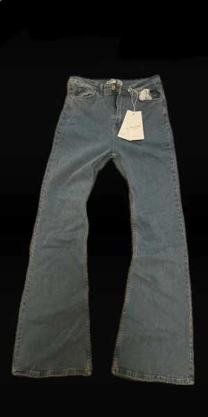 Blå utsvängda high waist jeans från Muddy storlek- 30 🧵 - Säljer ett par blå jeans från Muddy med utsvängda ben och klassisk femficksdesign i storkek 30 men passar någon med storlek 36. Jeansen har normal midja, bälteshällor och är gjorda i ett mjukt denimtyg. Perfekta för dig som gillar retrovibbar och en avslappnad look👀