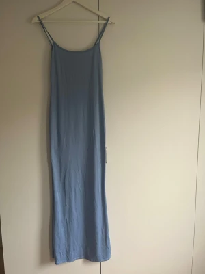 Ljusblå långklänning med tunna band - Säljer en enkel och stilren ljusblå långklänning med tunna axelband och slim passform. Storlek s