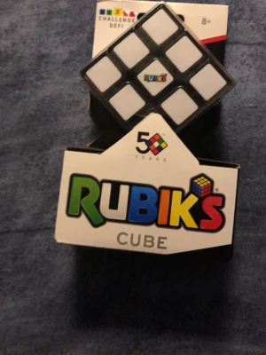 Rubiks kub 50-årsjubileum - Rubiks kub 3x3 i svart och vitt, levereras i originalförpackning med 50-årsjubileumsdesign. Klassisk hjärngympa och pussel för alla åldrar. Perfekt för dig som gillar utmaningar och vill testa din problemlösningsförmåga.