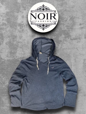 Blå hoodie från Hollister - Mysig blå hoodie från Hollister med klassisk huva och vita dragsnören. Hoodien har en liten broderad logga på bröstet och är tillverkad i mjukt bomullsmaterial. Perfekt för en avslappnad och stilren look.