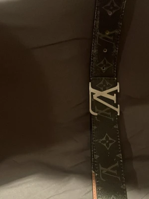 Bälte - Snyggt svart skärp från l.v med klassiskt monogrammönster och silverfärgat L.v spänne. Bältet har en stilren design och är gjort i skinn med beige insida. Perfekt accessoar för att lyfta vilken outfit som helst.