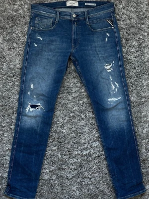 Blå slitna jeans från Replay - Säljer ett par blå jeans från Replay med skinny fit och slitningar på framsidan. De är i top skick och har noll skador. Skriv vid intresse, svarar dig inom 30 minuters tid. 