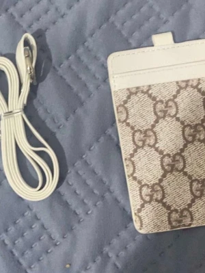 GG Plånbok med band  - Säljer en riktigt fet helt ny.  GG  plånbok med band runt halsen i vit/beige.  Jättefin färg, passar med mycket och bra kvalité.    Hör av er vid minsta lilla 